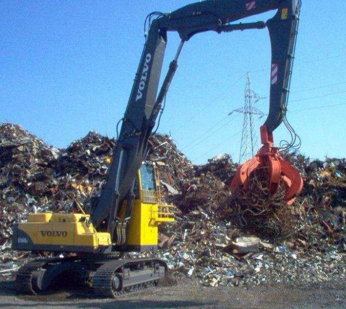 廢鋼抓斗在廢鐵處理廠作業中圖片